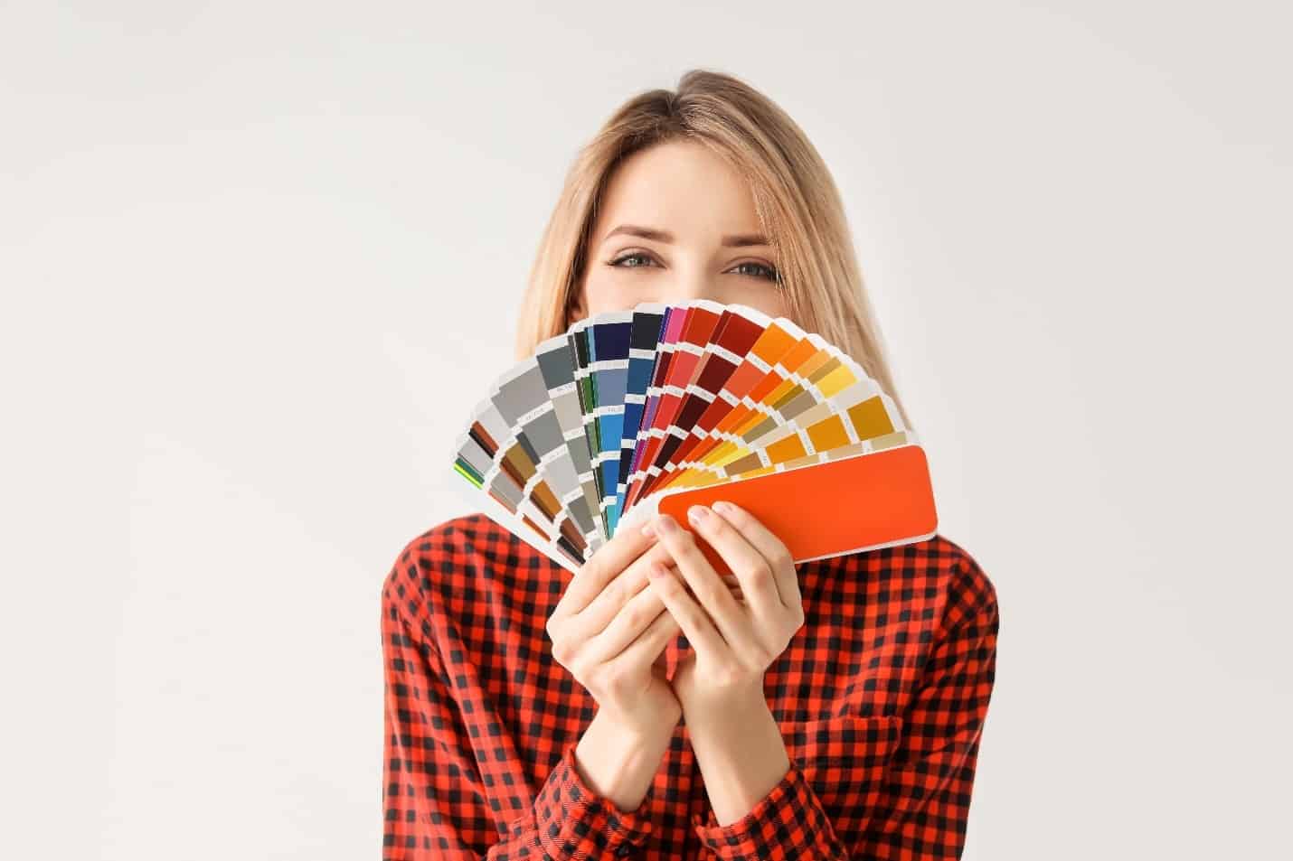 A woman holding a fan of color samples.