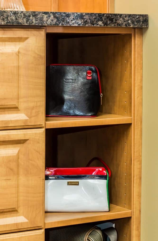 A designer handbag on a shelf in a closet.