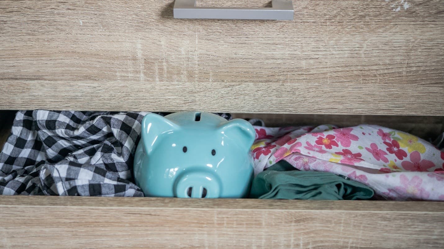 A piggy bank hiding in a clothes drawer.