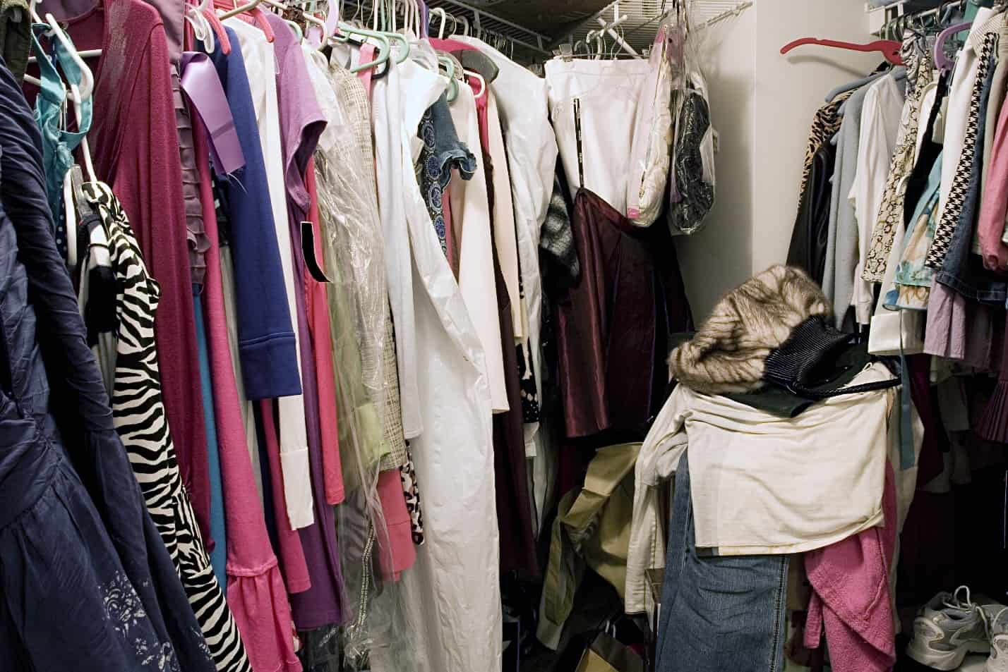 A messy closet full of clothes.