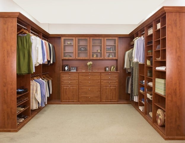 A custom walk-in closet with a wood finish.