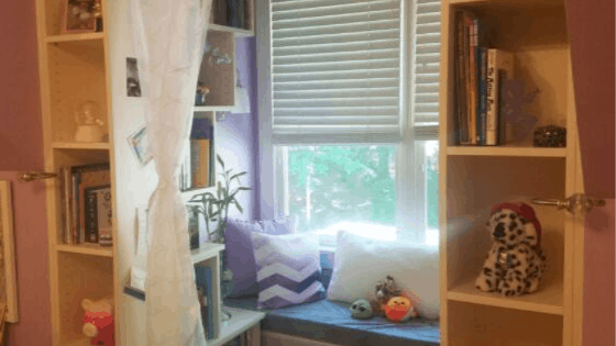 A child's bedroom organized with a reading nook and a bench.