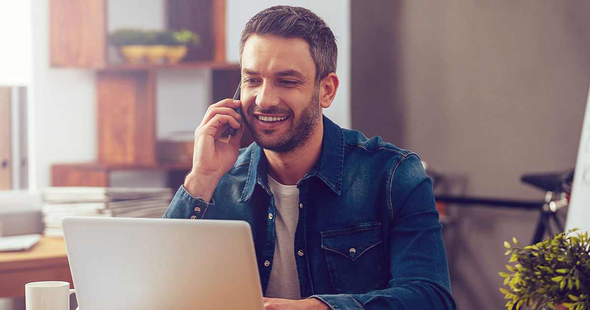A businessman talking on the phone from his home office.